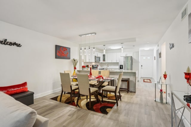 dining room with sink and light hardwood / wood-style floors