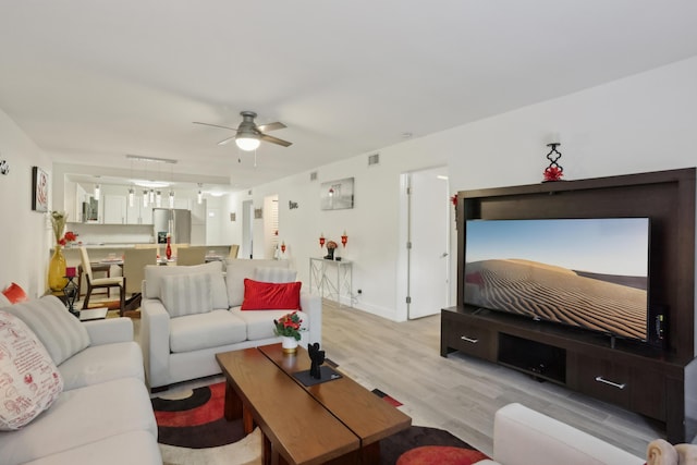 living room featuring ceiling fan and light hardwood / wood-style flooring