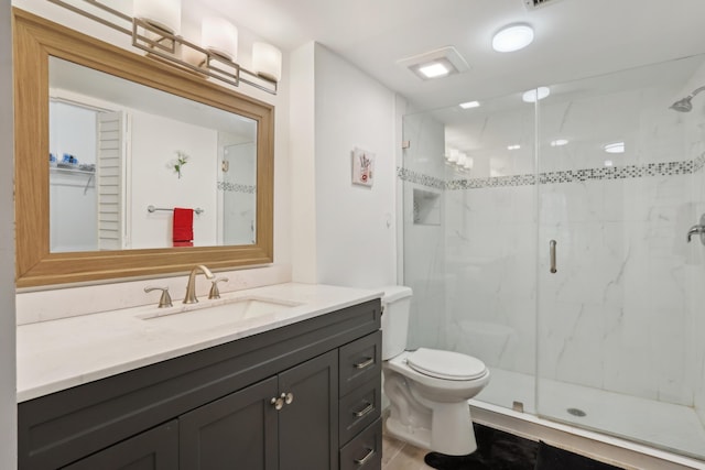 bathroom featuring vanity, an enclosed shower, and toilet