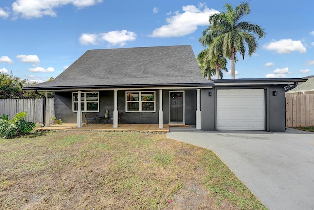 view of front of property with a front yard, a porch, and a garage