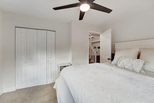 carpeted bedroom featuring ceiling fan and a closet