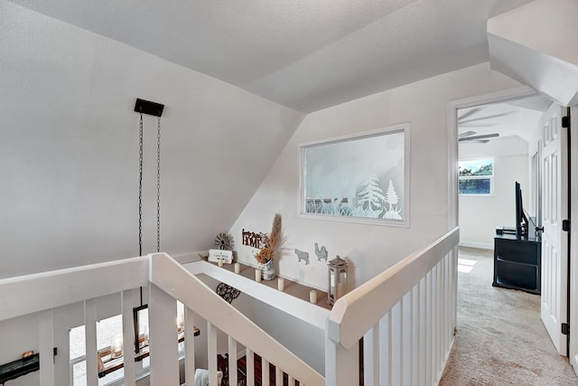 hallway featuring light colored carpet and vaulted ceiling