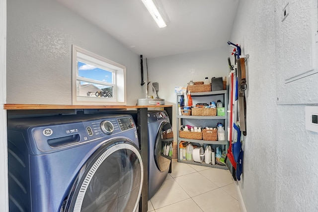 clothes washing area featuring tile patterned flooring and separate washer and dryer