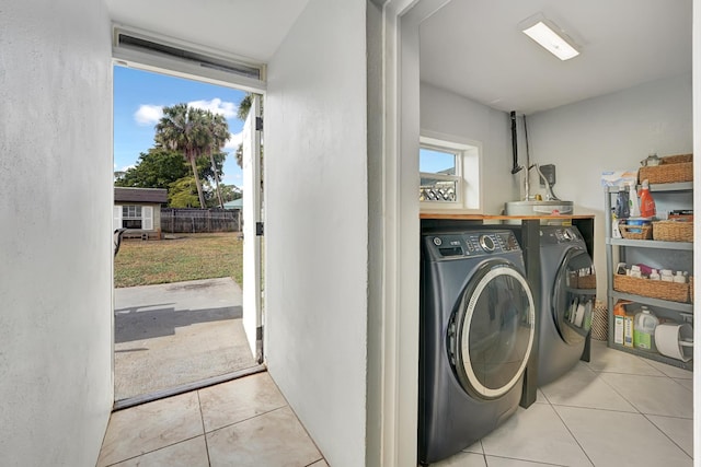 washroom with washer and clothes dryer and light tile patterned flooring