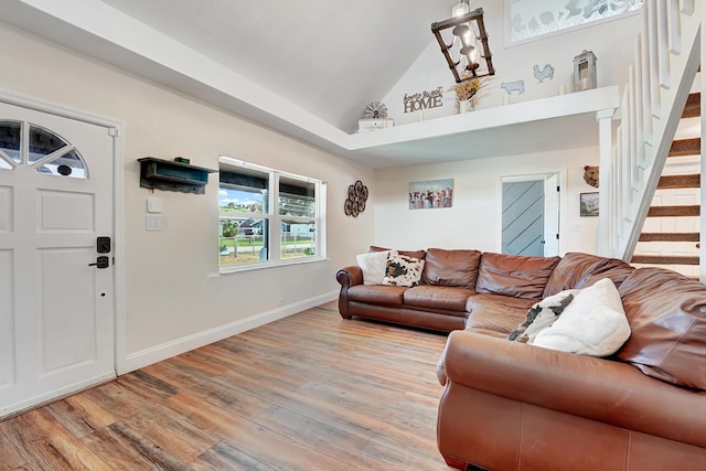 living room featuring high vaulted ceiling and light hardwood / wood-style flooring