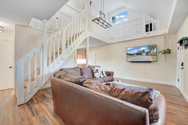 living room with wood-type flooring and a towering ceiling