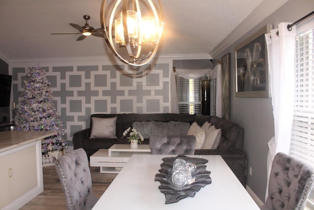 dining area with wood-type flooring, ceiling fan with notable chandelier, a textured ceiling, and crown molding