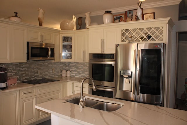 kitchen featuring light stone countertops, sink, tasteful backsplash, crown molding, and appliances with stainless steel finishes