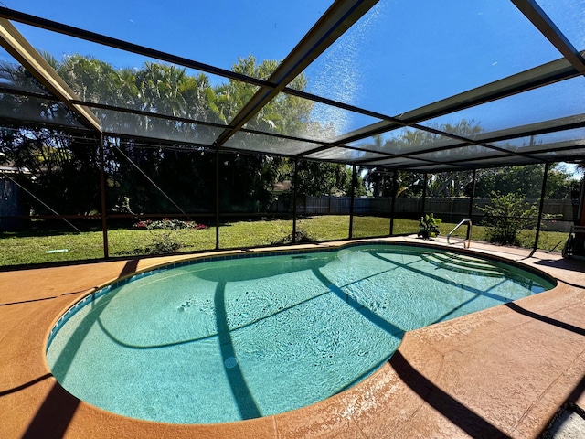 pool featuring a lanai, a lawn, a fenced backyard, and a patio area