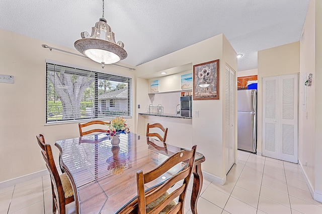 dining area with light tile patterned flooring and a textured ceiling