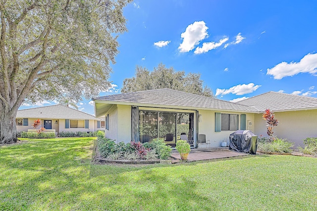 rear view of property featuring a patio area and a yard