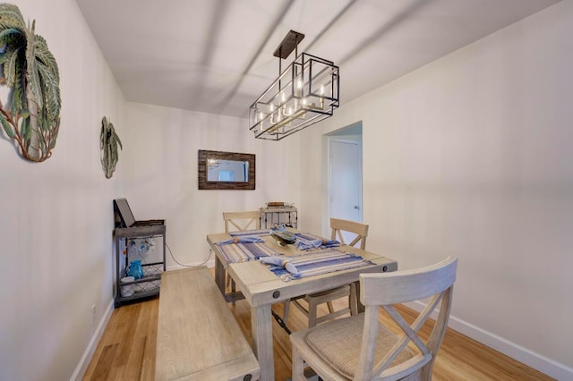 dining space featuring light hardwood / wood-style floors and a notable chandelier