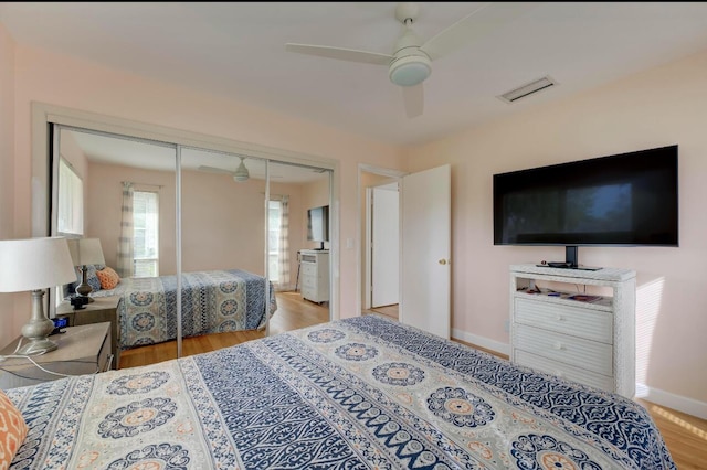 bedroom with ceiling fan, light hardwood / wood-style floors, and a closet