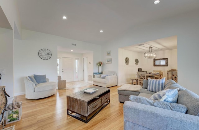 living room featuring light wood-type flooring and a chandelier