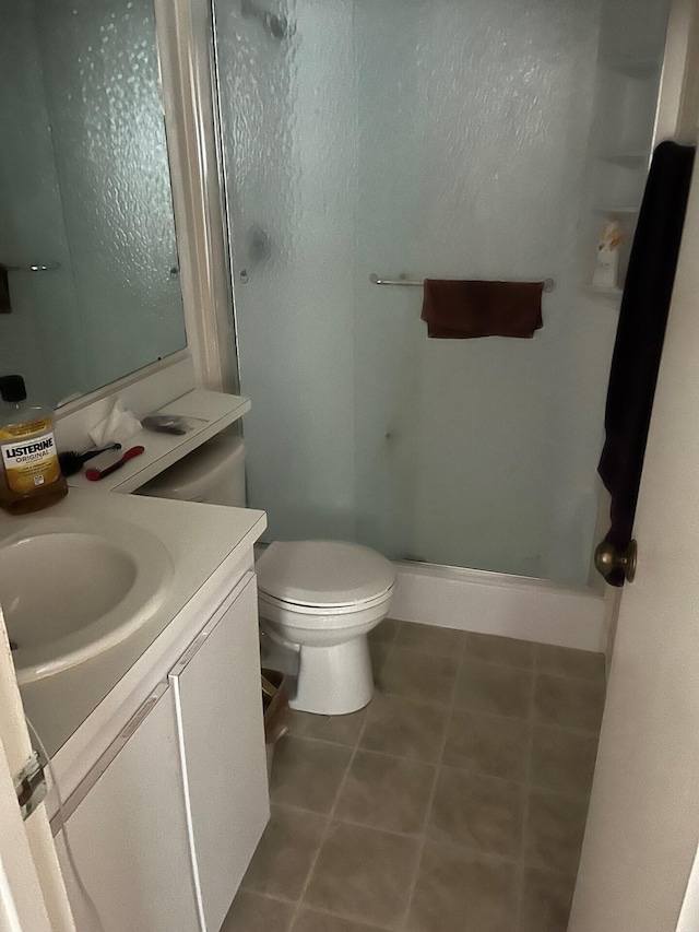 bathroom featuring vanity, an enclosed shower, and toilet