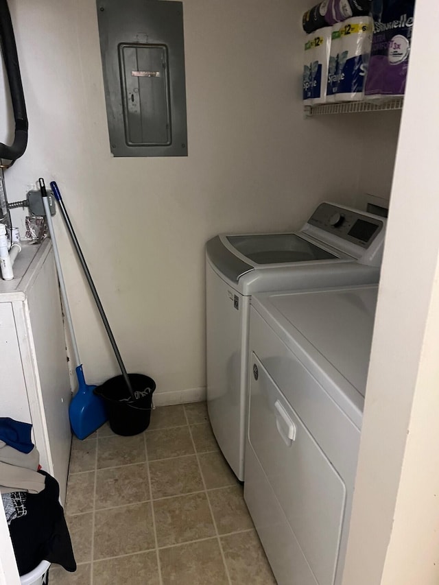 washroom featuring independent washer and dryer, electric panel, and light tile patterned floors