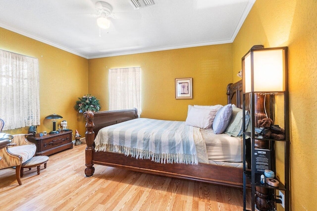 bedroom with hardwood / wood-style flooring, ornamental molding, and ceiling fan