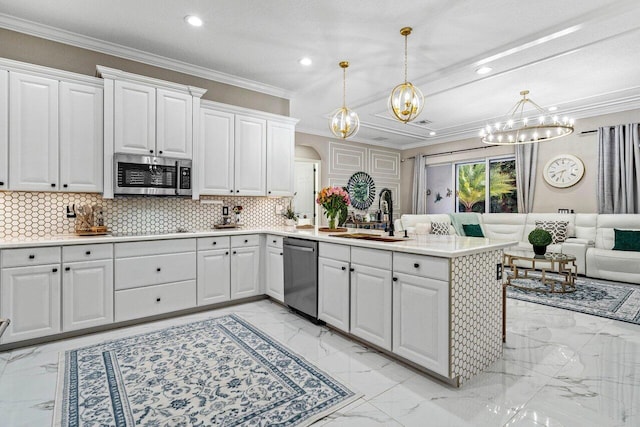 kitchen with ornamental molding, appliances with stainless steel finishes, a peninsula, marble finish floor, and a sink