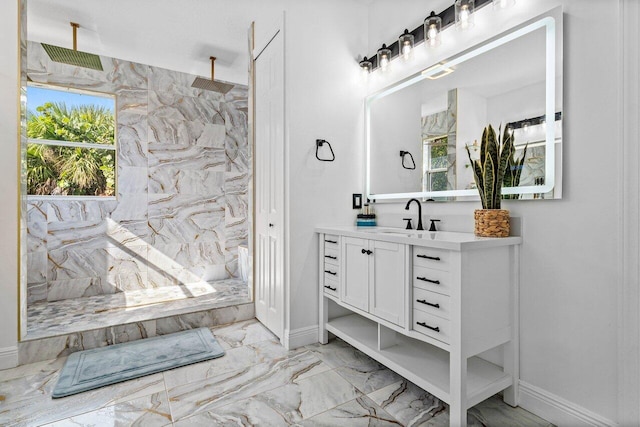 full bathroom with a marble finish shower, marble finish floor, vanity, and baseboards