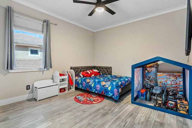 bedroom featuring a ceiling fan, crown molding, baseboards, and wood finished floors