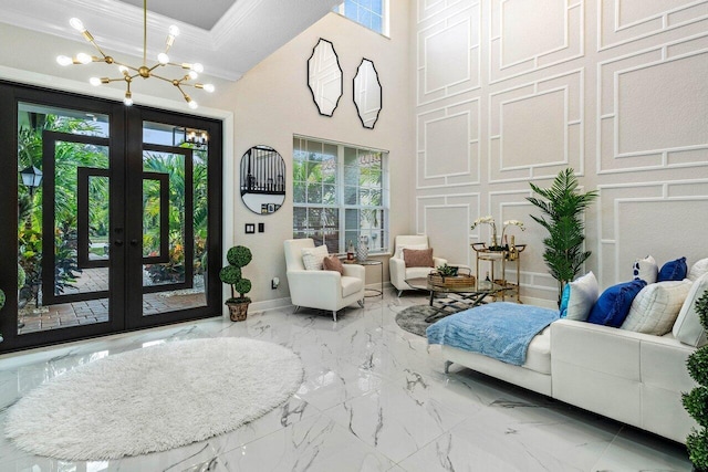 living area with an inviting chandelier, crown molding, french doors, and marble finish floor