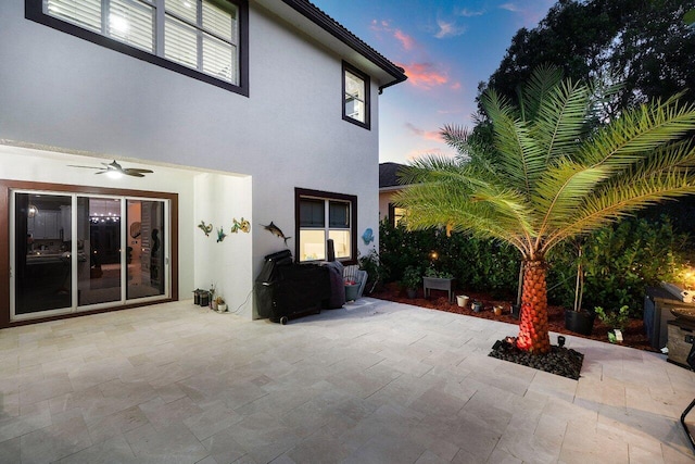 patio terrace at dusk featuring ceiling fan