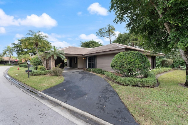 single story home featuring a carport and a front yard