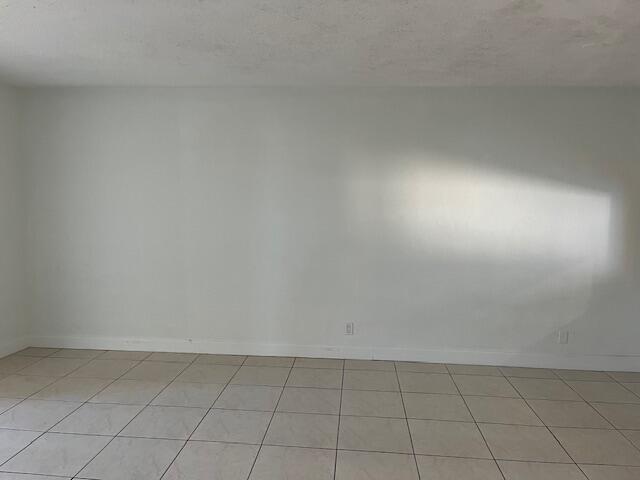 unfurnished room with light tile patterned flooring and a textured ceiling