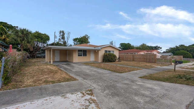 ranch-style house with a carport and a front lawn