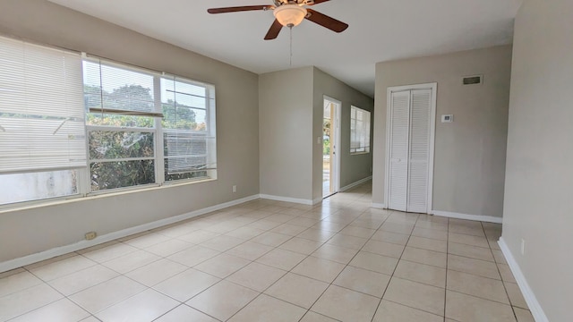 tiled spare room with ceiling fan