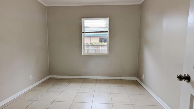 tiled spare room featuring ornamental molding