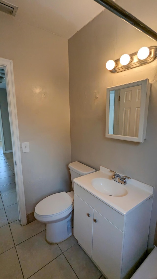 bathroom featuring tile patterned flooring, vanity, and toilet