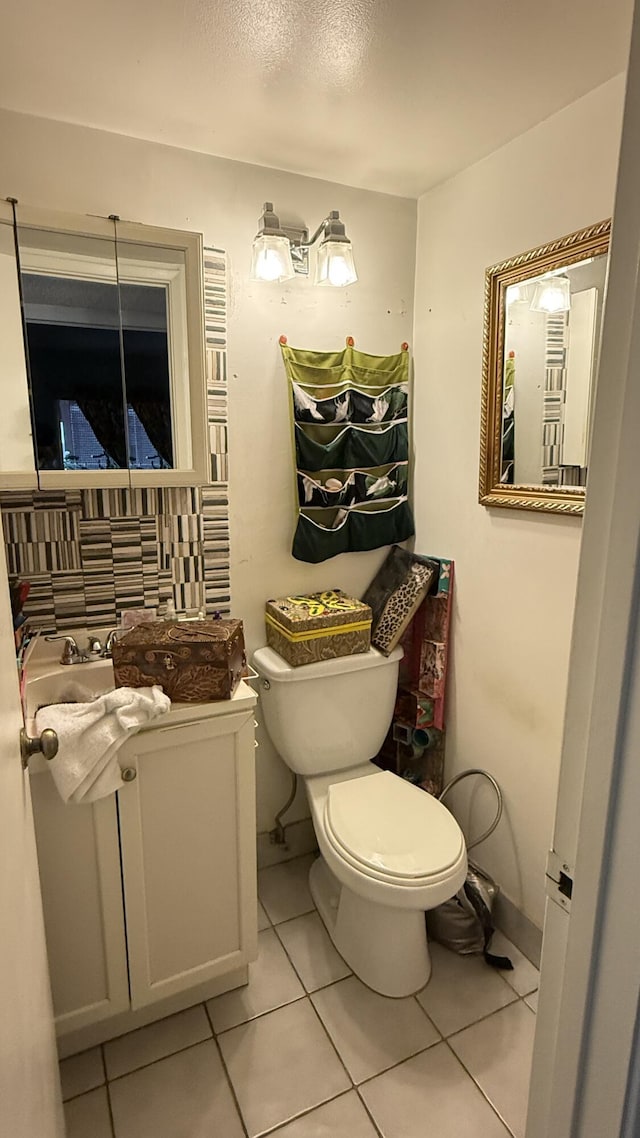 bathroom with tile patterned flooring, vanity, and toilet