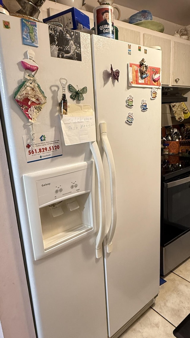 details with white fridge with ice dispenser, stainless steel range with electric cooktop, exhaust hood, and light brown cabinets