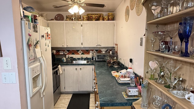 kitchen with sink, decorative backsplash, ceiling fan, white fridge with ice dispenser, and light tile patterned floors