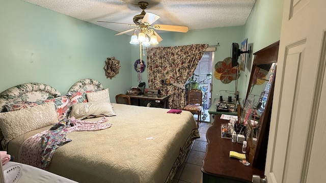 tiled bedroom featuring ceiling fan and a textured ceiling