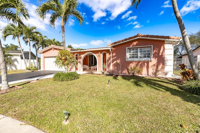 mediterranean / spanish house with a garage and a front lawn