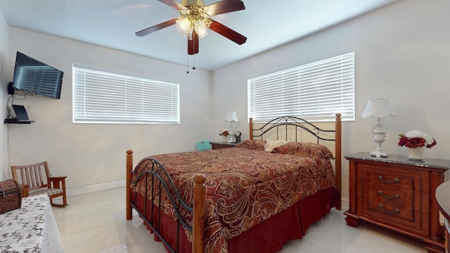 tiled bedroom featuring multiple windows and ceiling fan