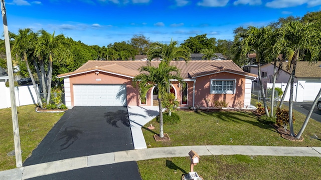 view of front of property featuring a front yard and a garage