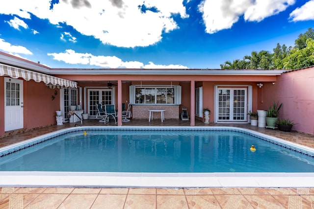 view of swimming pool featuring french doors, a patio, and ceiling fan