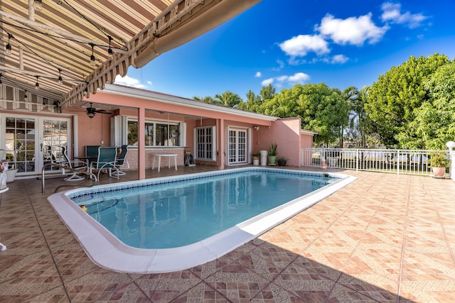 view of pool with ceiling fan, a patio, and french doors