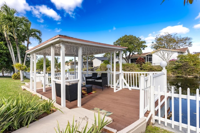 deck featuring outdoor lounge area, a gazebo, and a water view