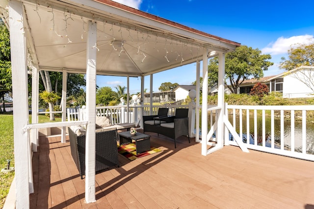 wooden deck featuring an outdoor living space and a water view