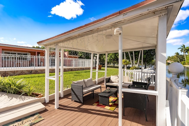 wooden deck featuring a gazebo, an outdoor hangout area, and a lawn