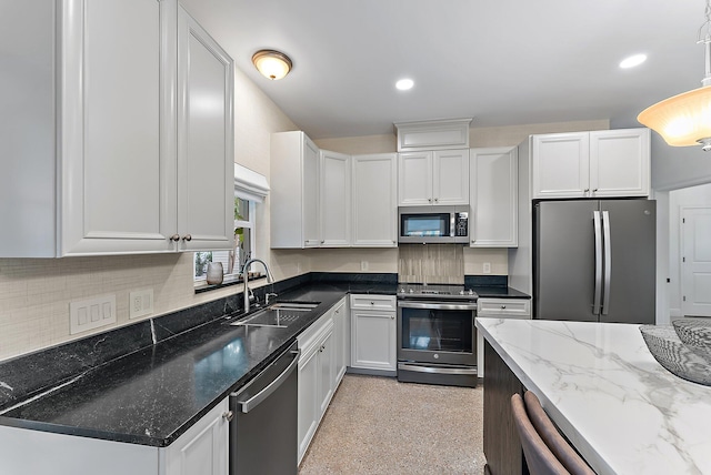 kitchen featuring decorative light fixtures, stainless steel appliances, white cabinetry, and sink