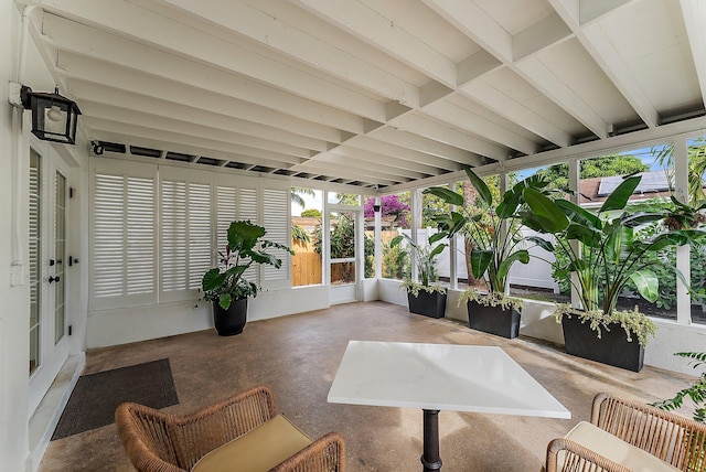 sunroom featuring beam ceiling