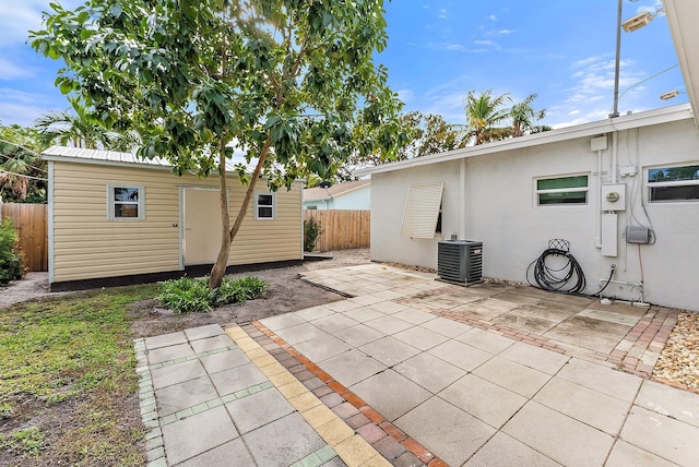 back of house featuring an outbuilding, cooling unit, and a patio