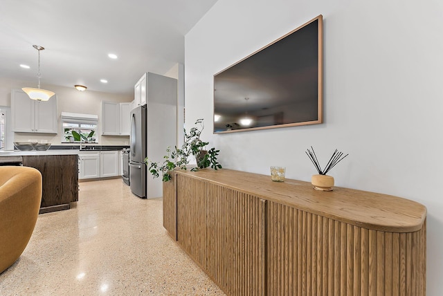 kitchen featuring stainless steel appliances, sink, decorative light fixtures, white cabinets, and butcher block counters