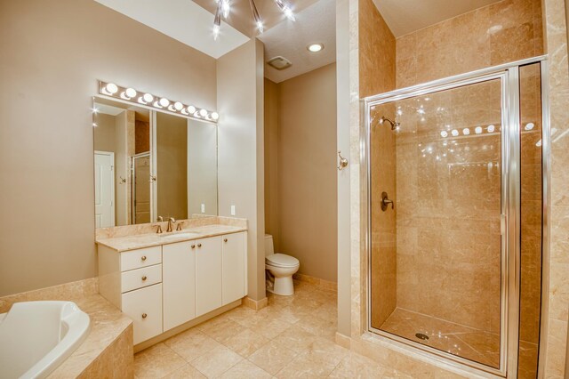 full bathroom featuring a stall shower, a garden tub, toilet, vanity, and tile patterned floors