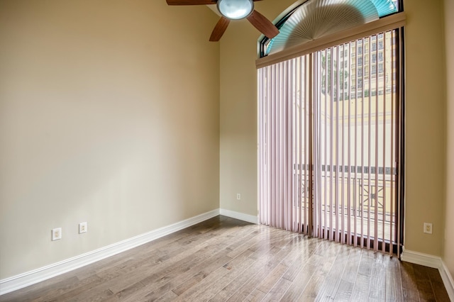 spare room with wood finished floors, baseboards, and ceiling fan